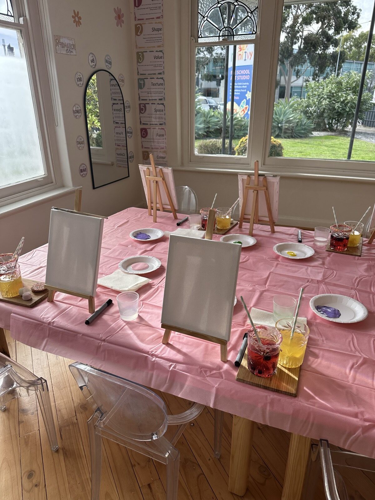Mini Ivy birthday party table set up with easels and canvases