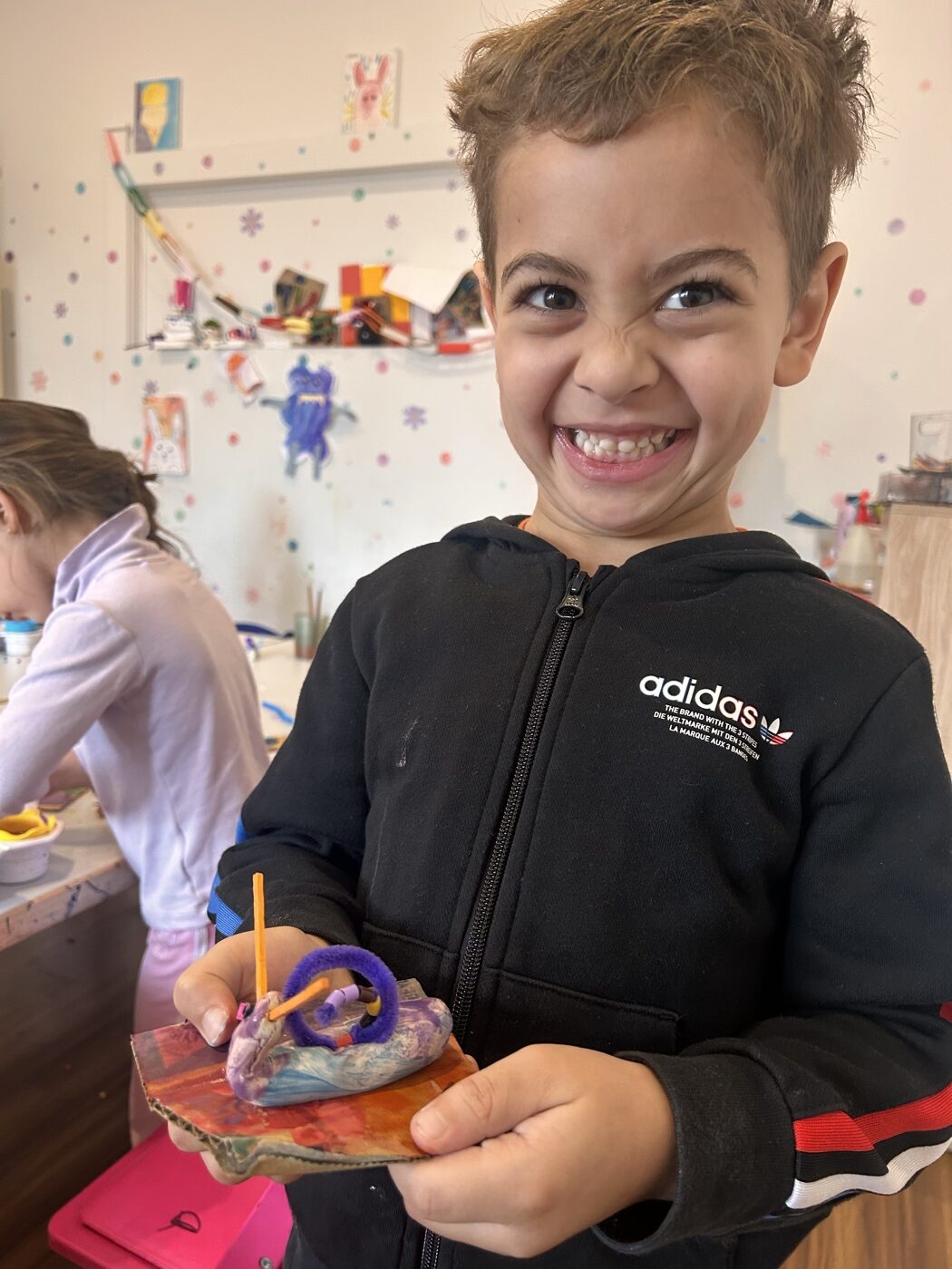 Delighted child showing their clay creation at Mini Ivy Torrensville