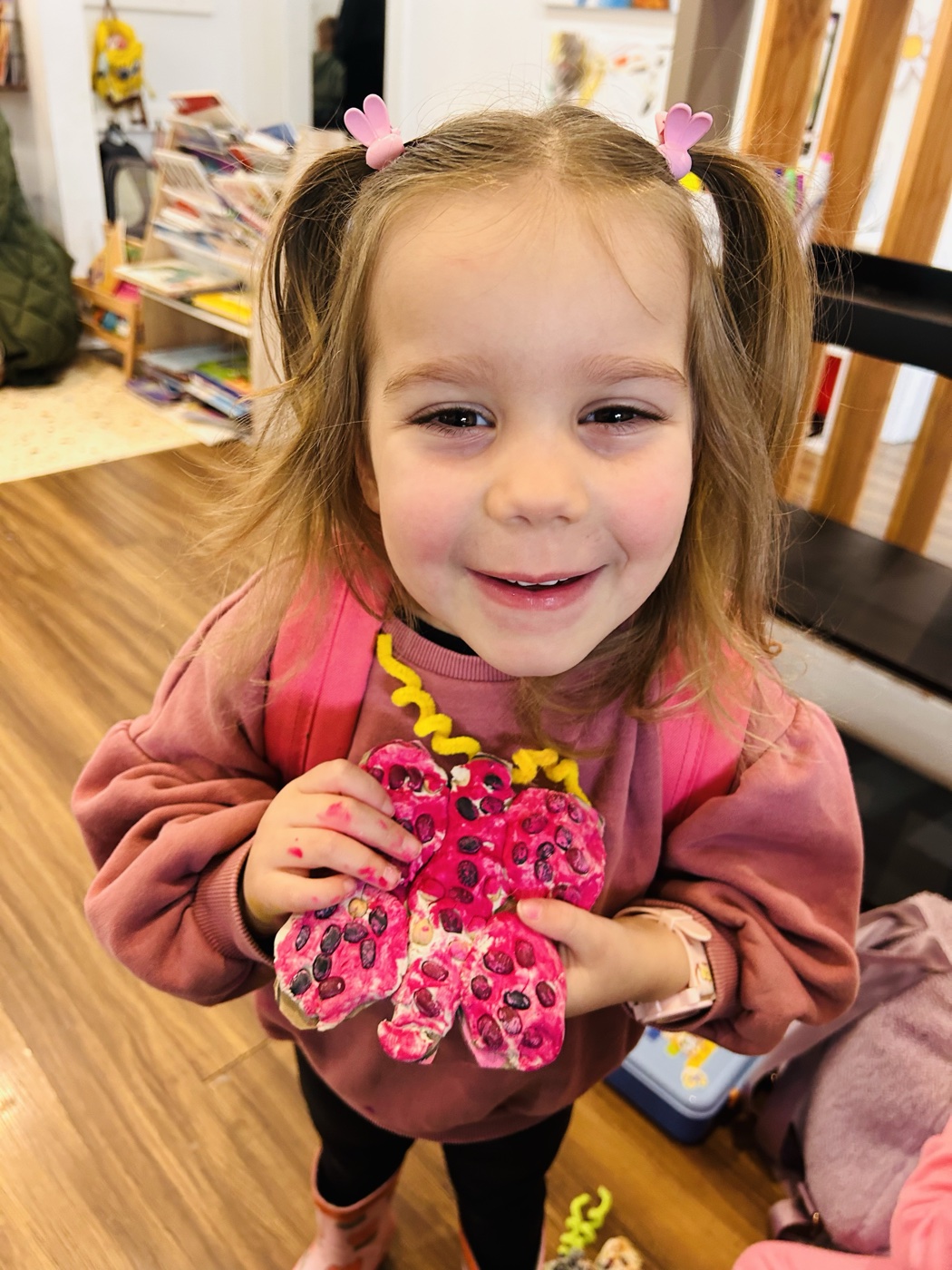 Smiling child holding a flower collage made at Mini Ivy Torrensville
