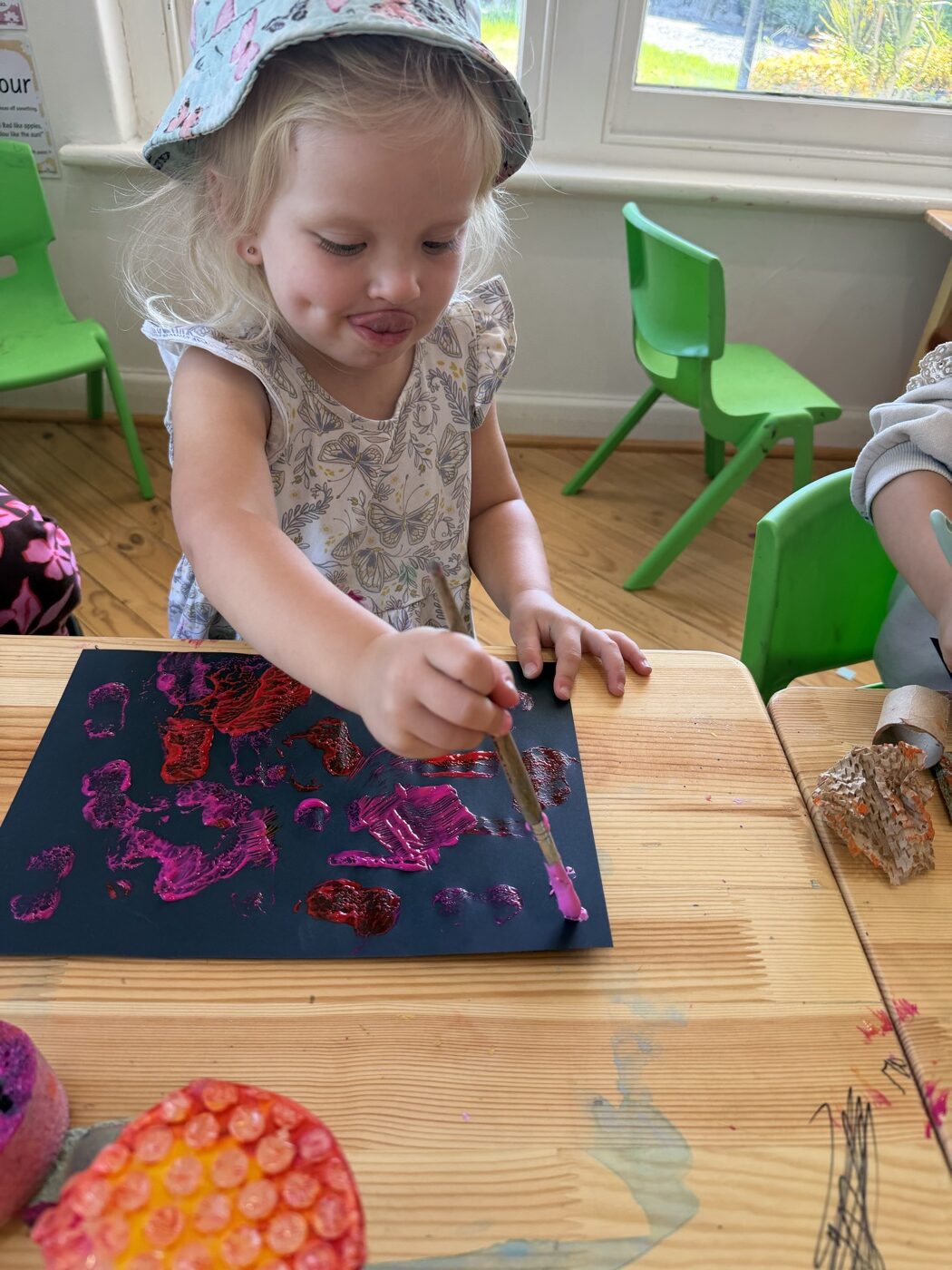 Toddler exploring texture printing with paint at Mini Ivy art studio