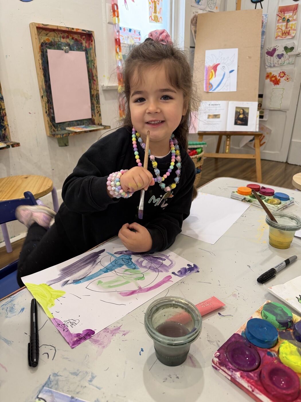 Child painting with watercolours during a teacher-led lesson at Mini Ivy Adelaide